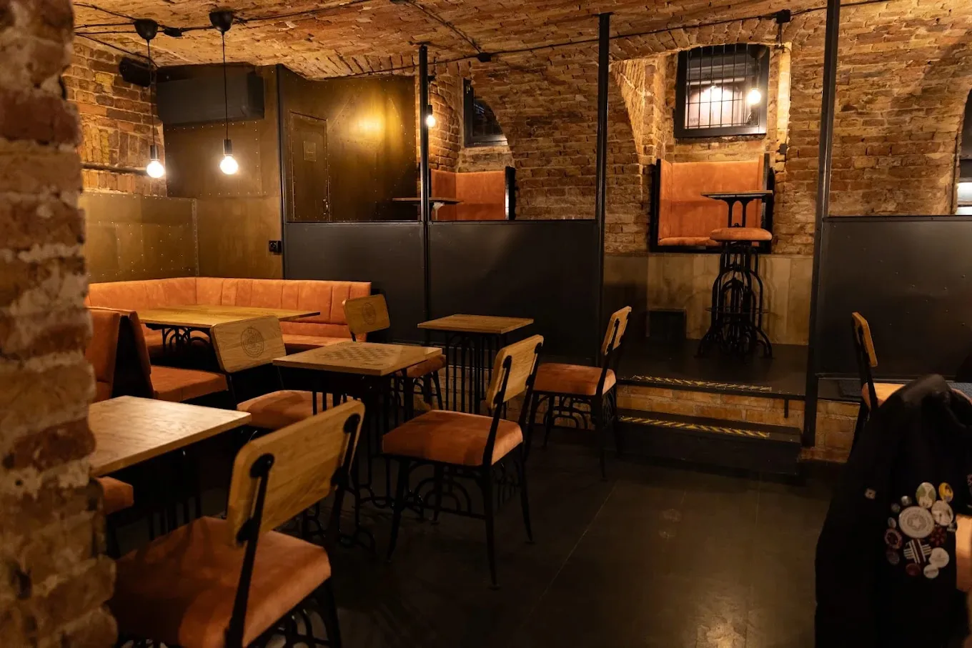The ÓDA cellar room: brick vaulting, rust-brown leather benches and bare bulbs